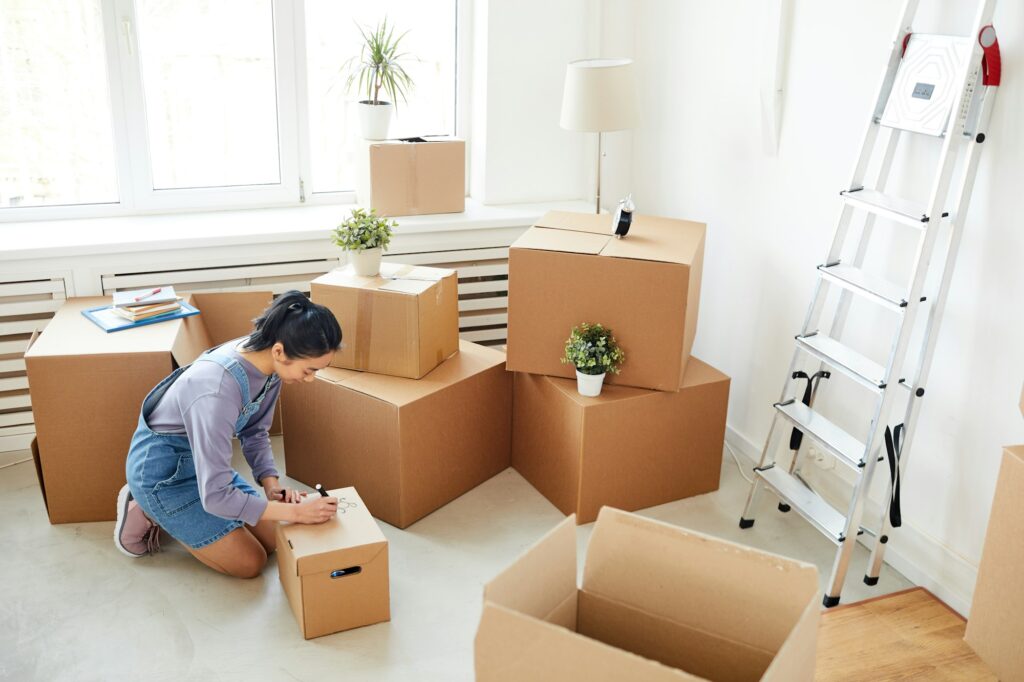 Young Woman Packing Boxes for Relocation